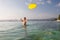 Woman plays frisbee in the water of beautiful ocean