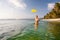 Woman plays frisbee in the water of beautiful ocean