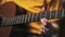 A woman plays the guitar. The fingerboard and frets in close-up. Learning to play the guitar