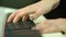 Woman plays by hands on white digital piano, close-up shooting with defocus. Girl is playing by fingers on keyboard or