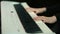 Woman plays by hands on white digital piano, close-up shooting with defocus. Girl is playing by fingers on keyboard or