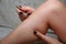 Woman plucks out leg hair with tweezers