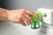 Woman plugging electric vaporizer with insect repellent liquid at home, closeup