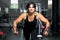 Woman plus size in gym doing exercises with training apparatus,