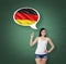 Woman is pointing out the thought bubble with German flag. Green chalk board background.