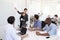 Woman pointing at whiteboard at a meeting in a busy office