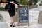 Woman points hand on the chalk stand, advertising street