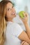 Woman poised to eat ripe green apple