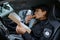 Woman police officer eating donut in car