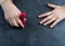 Woman polishing her nails on the gray background.