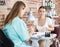 Woman polishing nails to unhappy female client in modern beauty salon