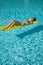 A woman in the pool floats on a blown mattress