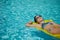 A woman in the pool floats on a blown mattress