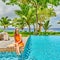 Woman by poolside. Resort swimming pool at Seychelles