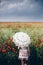 Woman in Poppies field holding umbrella