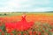 Woman poppy field red dress. Happy woman in a long red dress in a beautiful large poppy field. Blond stands with her