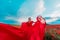 Woman poppy field red dress. Happy woman in a long red dress in a beautiful large poppy field. Blond stands with her