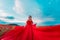 Woman poppy field red dress. Happy woman in a long red dress in a beautiful large poppy field. Blond stands with her