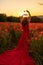 Woman poppy field red dress sunset. Happy woman in a long red dress in a beautiful large poppy field. Blond stands with