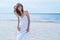 Woman Portrait on the beach. Happy beautiful curly-haired girl full-length, the wind fluttering hair. Spring portrait on the beach