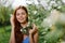 Woman portrait beautifully smiling with teeth spring happiness in nature against a green tree hand touch tenderness