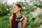 Woman portrait beautifully smiling with teeth spring happiness in nature against a green tree hand touch tenderness