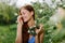 Woman portrait beautifully smiling with teeth spring happiness in nature against a green tree hand touch tenderness