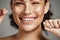 Woman portrait, dental floss and flossing teeth with smile for oral hygiene, health and wellness on studio background