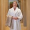 Woman, portrait and happy at spa for wellness, holiday and luxury with towel, robe and getting ready for massage. Person