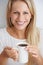 Woman, portrait and happy in studio with coffee for morning caffeine, break and energy for relax and drink. Person, face