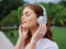 Woman portrait meditation and tranquility in headphones happiness smile with her eyes closed in a white T-shirt