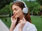 Woman portrait meditation and tranquility in headphones happiness smile with her eyes closed in a white T-shirt