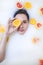 Woman portrait in milk bath with oranges, lemons and grapefruits. Fashion model, spa and skin care concept.