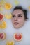 Woman portrait in milk bath with oranges, lemons and grapefruits. Fashion model, spa and skin care concept.