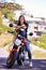 Woman, portrait and motorcycle in city with helmet for road trip, travel or outdoor journey in nature. Extreme female