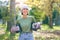 Woman portrait, plant and gardening in a park with trees in nature environment, agriculture or garden. Happy volunteer