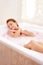 Woman portrait, rose and milk bath with flower petals and luxury bathroom treatment. Beauty body care, cleaning and