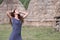 Woman pose front of straw houses