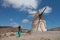 A woman poses in front of a windmill in Cabo de Gata Andalucia, Spain and is hit by a strong wind