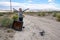 Woman poses with an old busted broken CRT television in the middle of the desert, near the Salton Sea of California