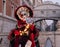 Woman poses in ornate, detailed costume, mask and hat in front of the Bridge of Sighs, St Mark`s Square  during Venice Carnival, I
