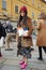 Woman poses for photographers with Chanel bag and leopard fur before Gucci fashion show, Milan Fashion Week