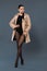 Woman posing in black pantyhose and beige trench