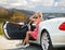 Woman posing in convertible car at big sur coast