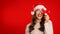 Woman posing with little wrapped Christmas present covering eye, studio