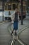 A woman posing near a vintage streetcar.