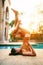 Woman posting warrior yoga pose beside sport water pool