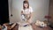 Woman potter is drying ceramic plate by hot air gun in pottery studio