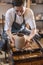 Woman potter working on a Potter`s wheel making a vase. Master pulls the jug off the circle gently holding it in hands