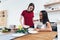 Woman pour milk into bowl her friend in kitchen